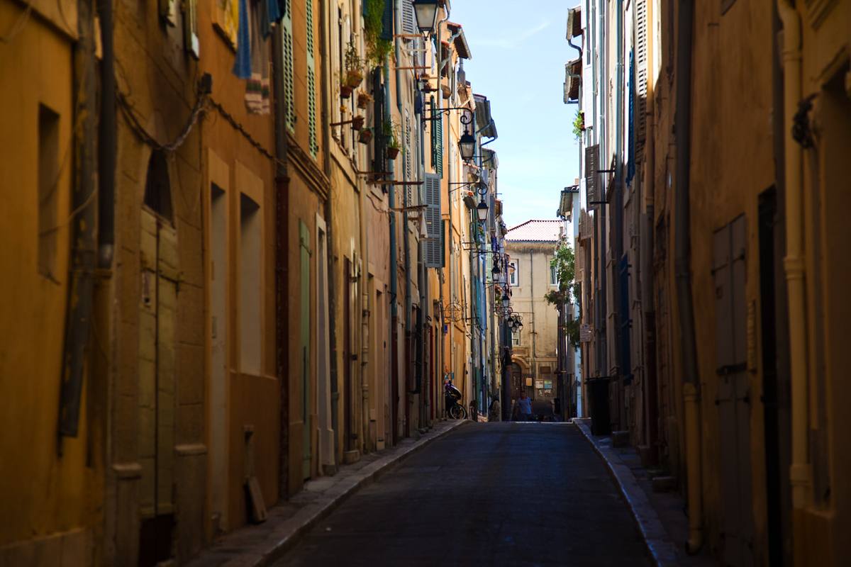 Ruelle étroite aux façades ocre et aux volets colorés dans le quartier du Panier à Marseille